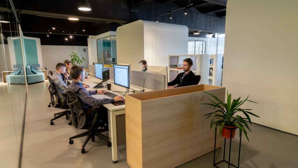 a group of people sitting at desks in an office