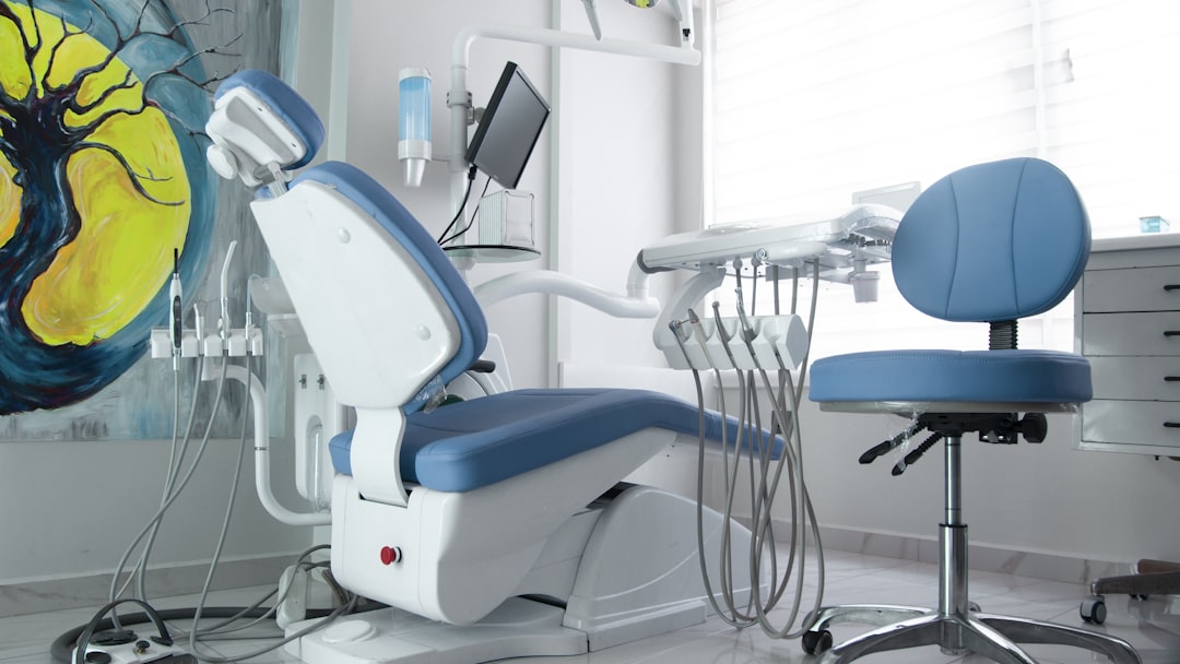 a dentist chair in a room with a painting on the wall
