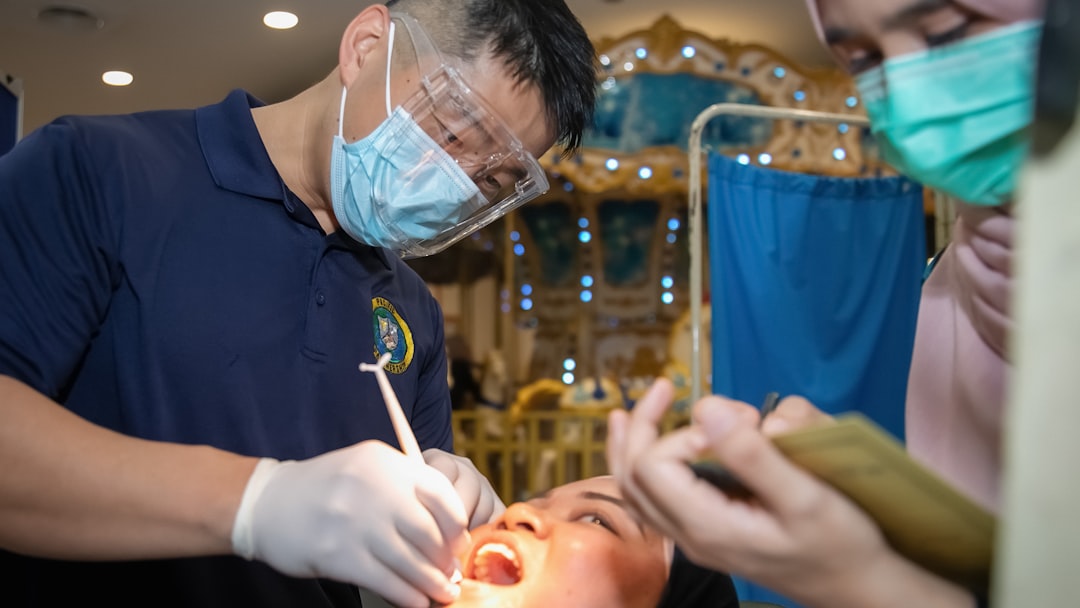 Dentist examining a patient's teeth with assistant