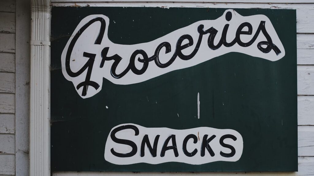Groceries and snacks sign on wooden wall