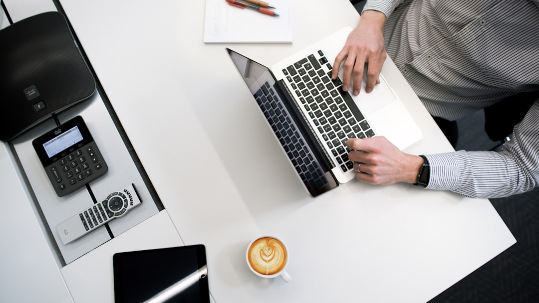 person using laptop on white wooden table