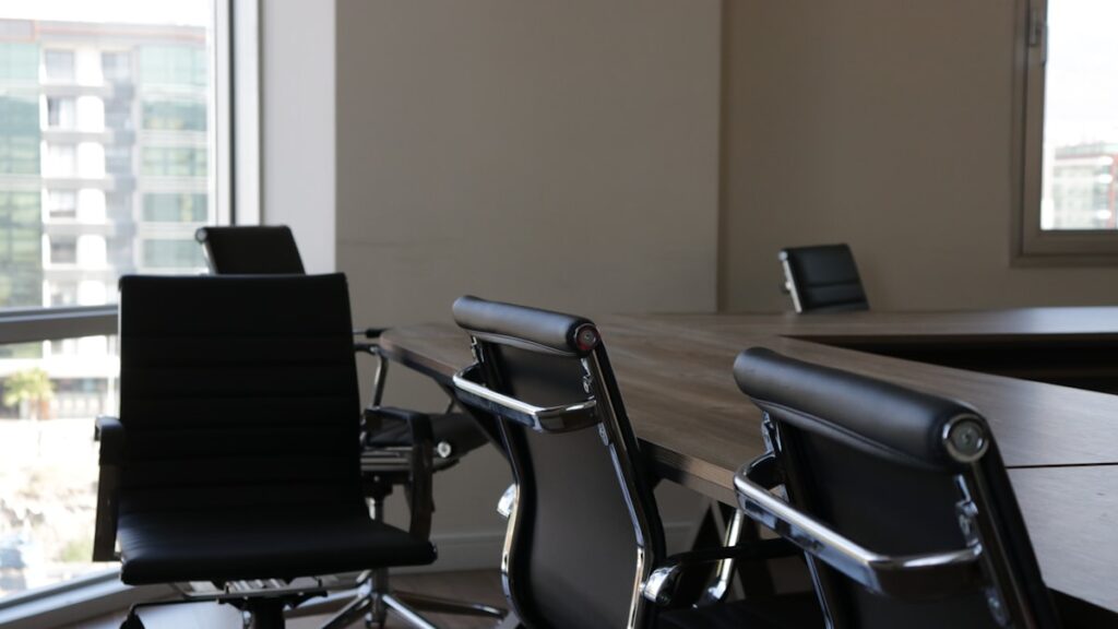 five black rolling chars front of desk