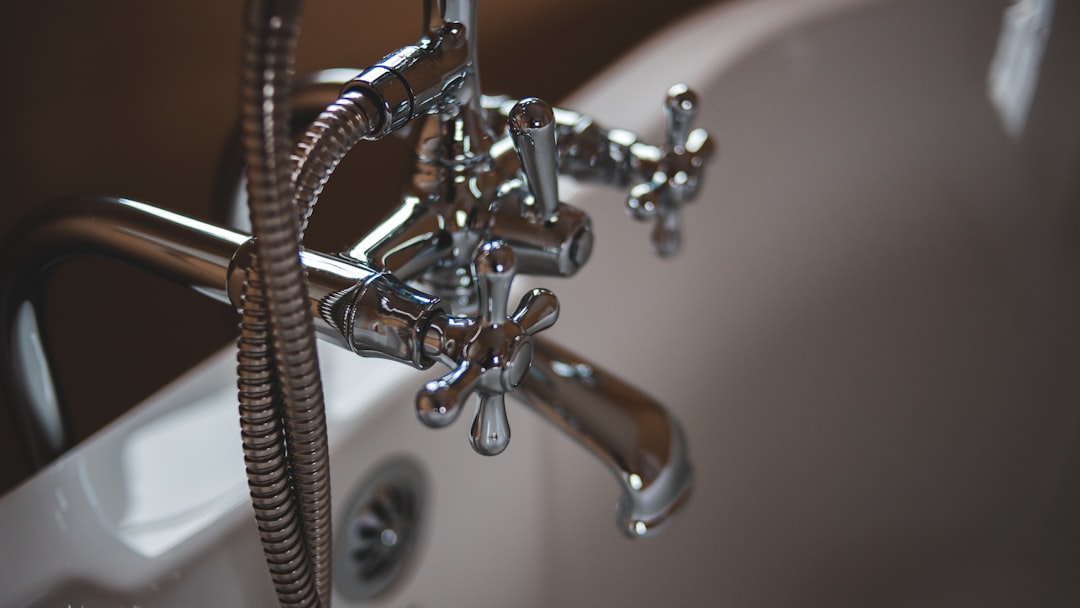 silver water faucet on white ceramic sink