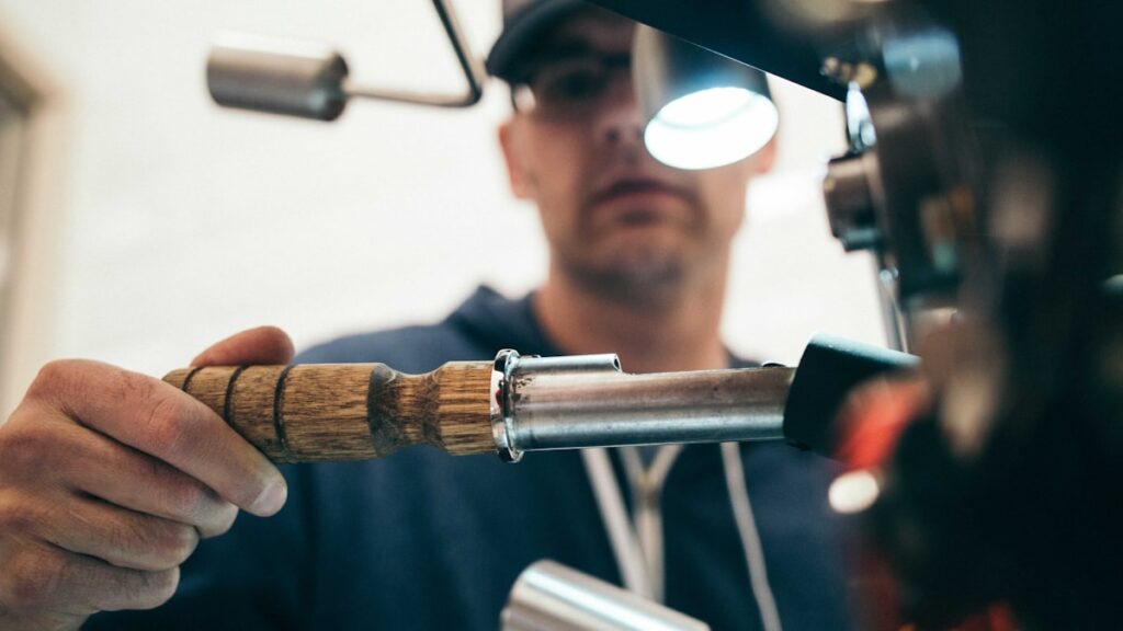 man wearing black pullover hoodie holding tool