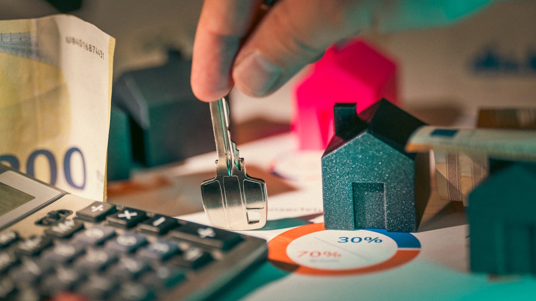 hand holding key over house models