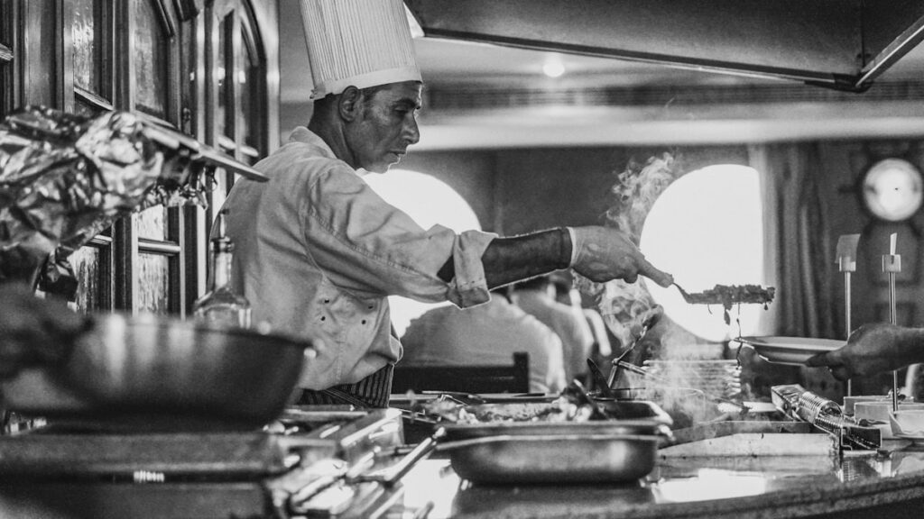 grayscale photo of man cooking