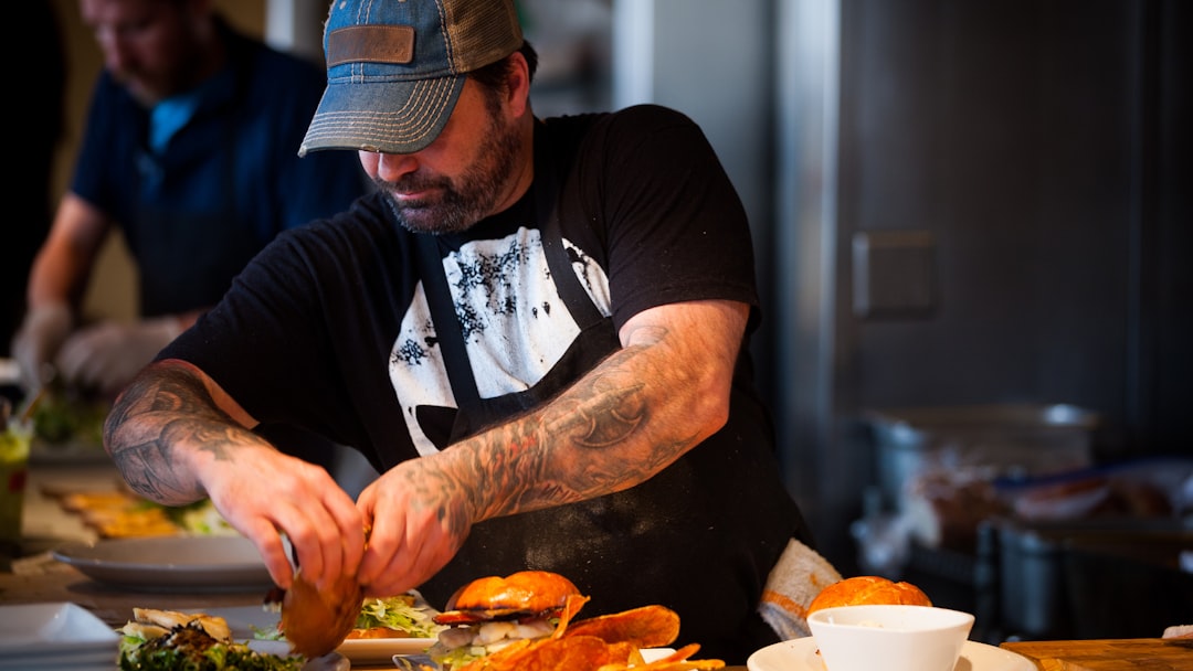 man standing beside table while holding food