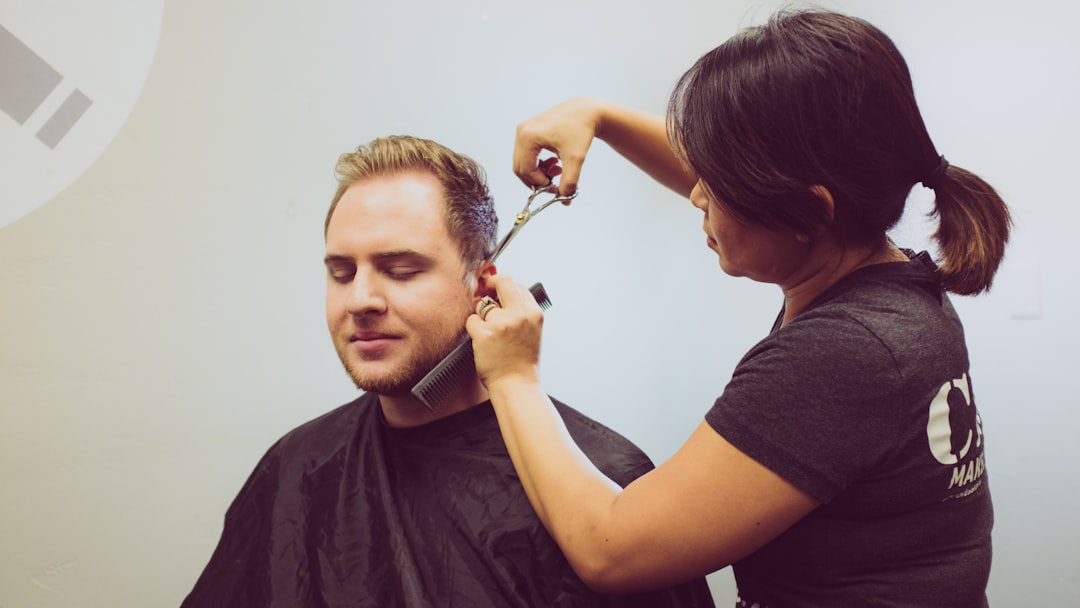 woman trimming the hair of a man