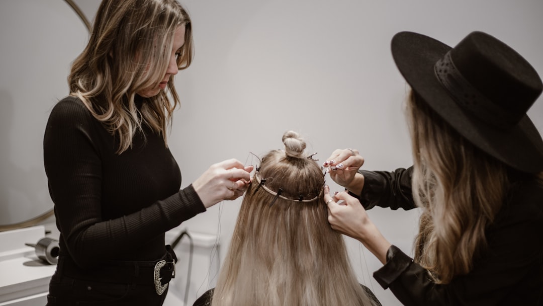 a woman getting her hair styled by another woman