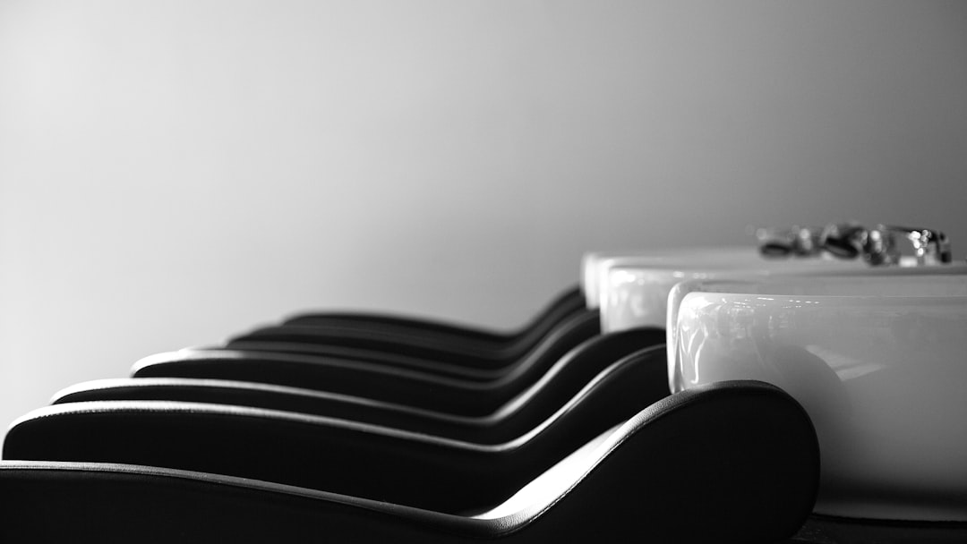 a row of black and white chairs next to a sink