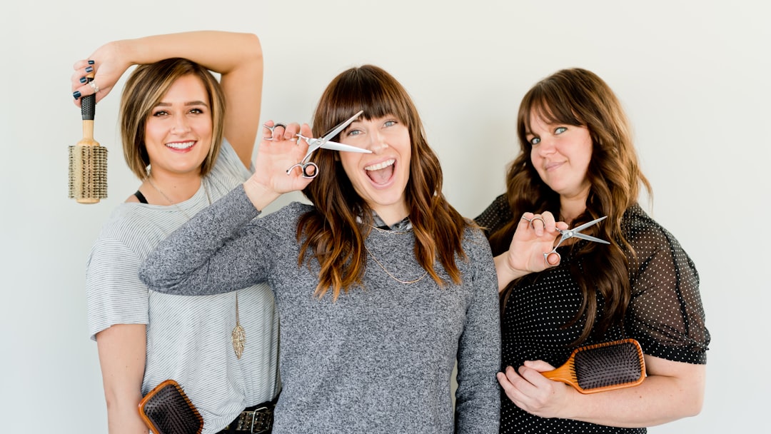 three women holding scissors and brush