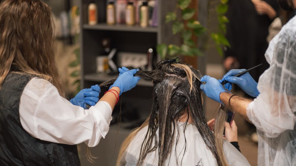 a woman getting her hair done by a hair stylist
