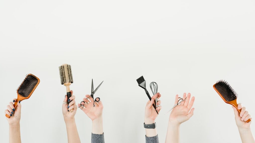 person holding silver and black hair brush