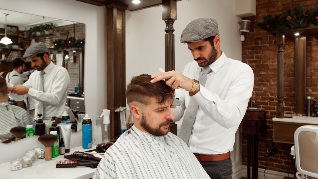 man in white dress shirt cutting hair of man