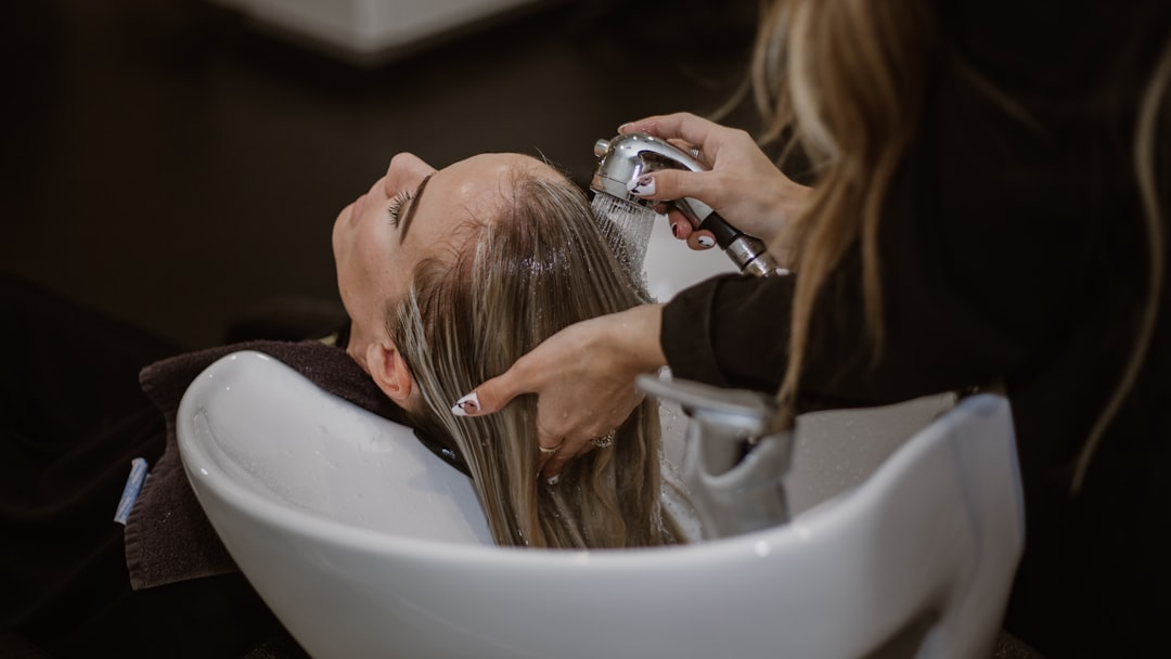a woman getting her hair cut by a hair stylist