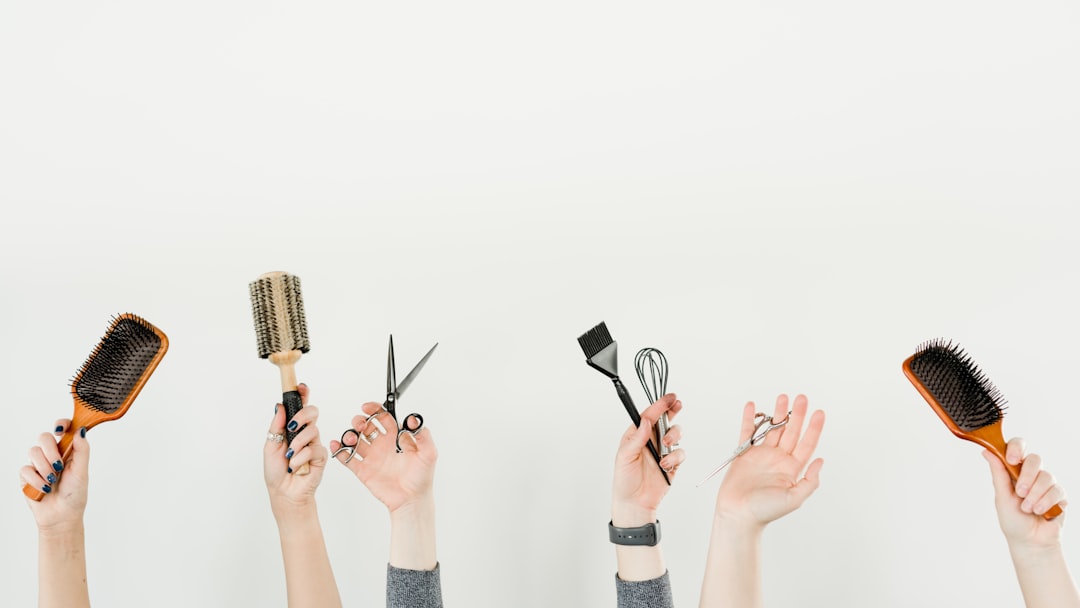 person holding silver and black hair brush
