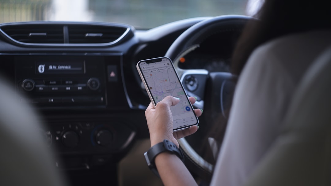 A woman holding a cell phone while driving a car