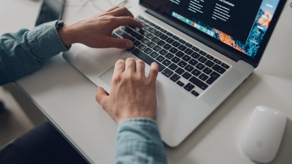 person wearing long-sleeve top working on laptop