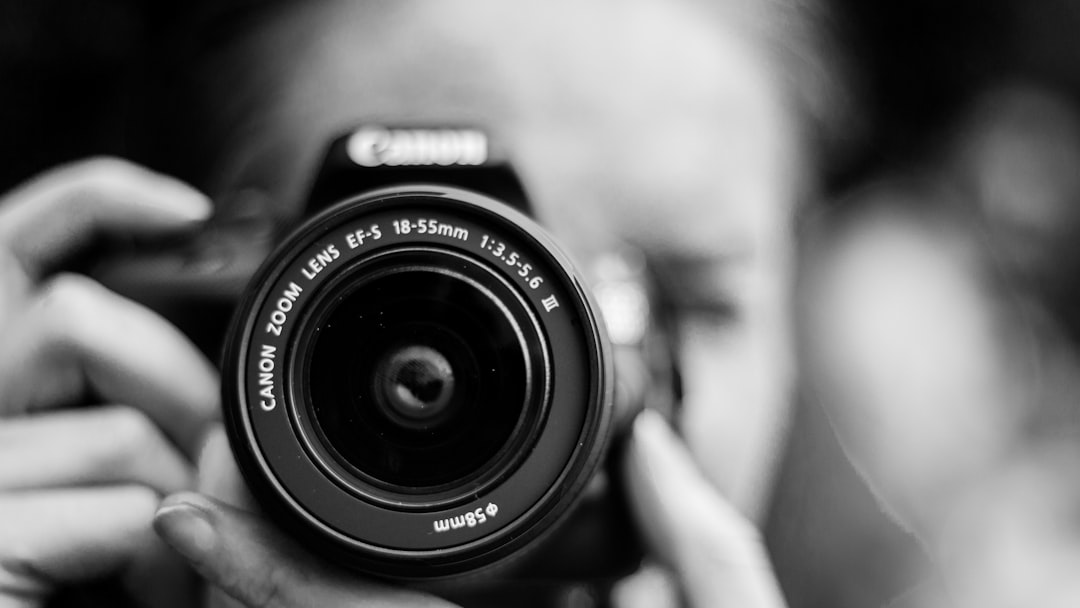 person taking photo using Canon camera in shallow focus lens
