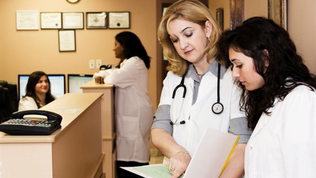 woman in white long sleeve shirt holding white printer paper
